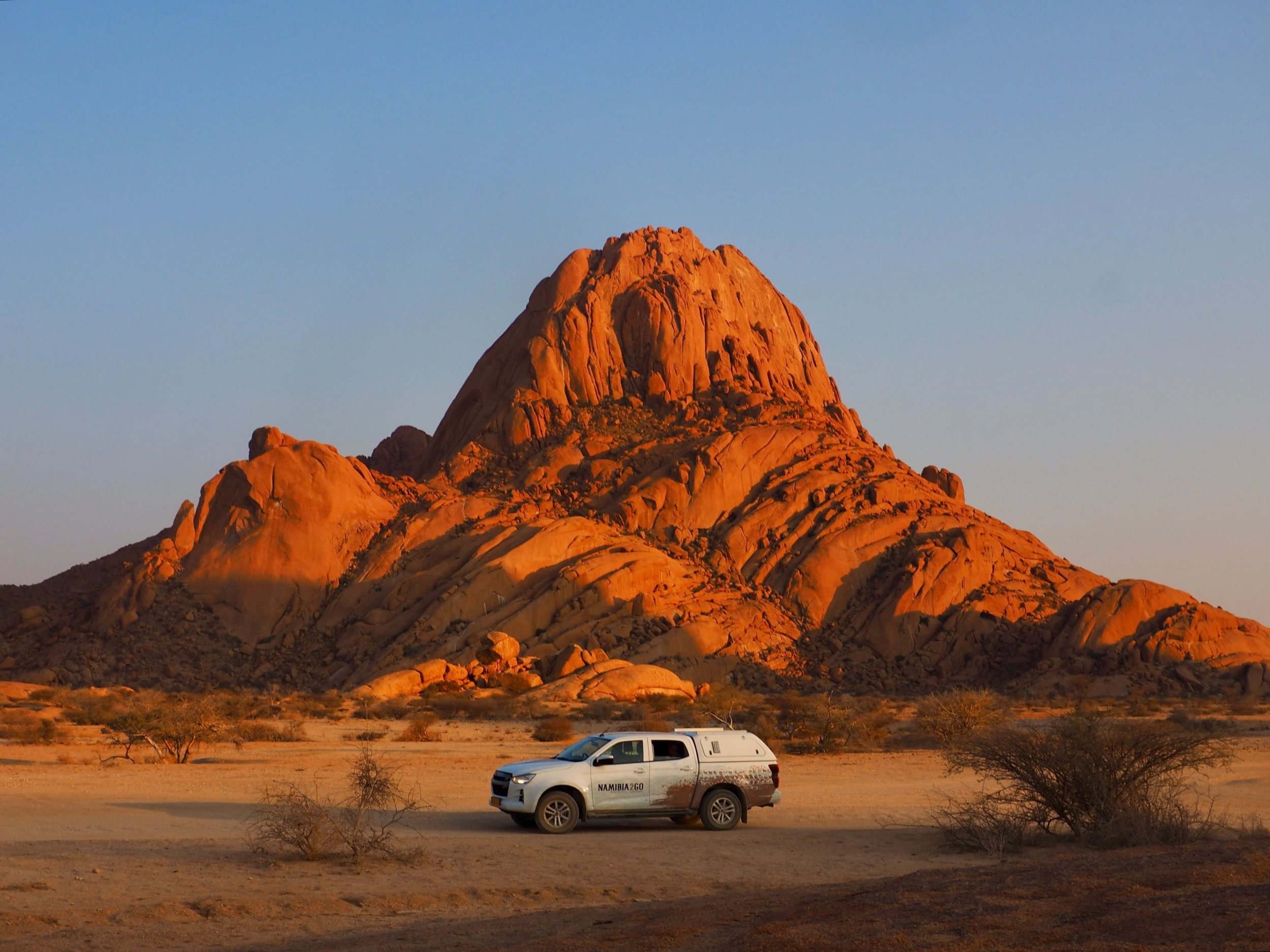 Un todoterreno de safari aparcado a los pies de Spitzkoppe al atardecer